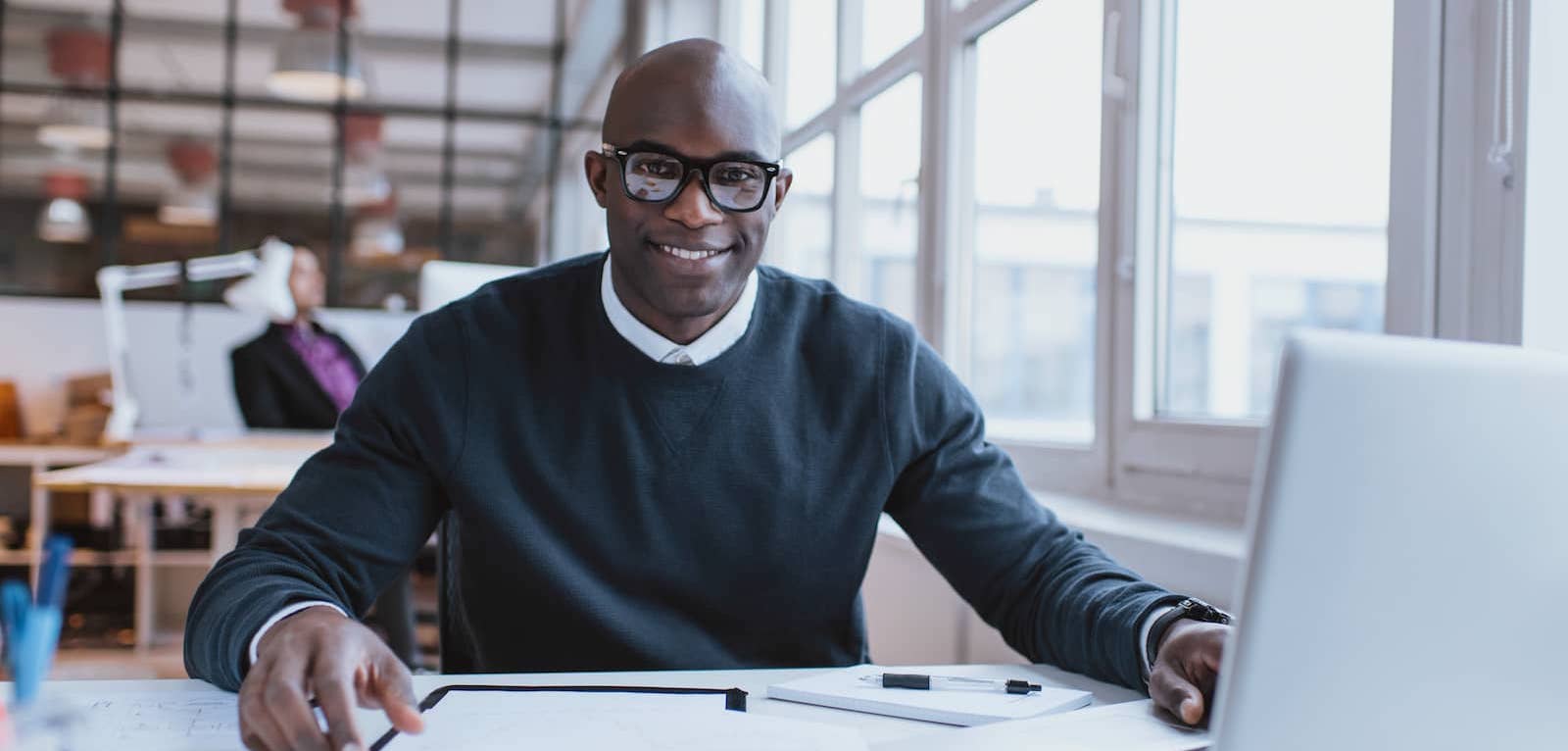 Business person working in open office on laptop